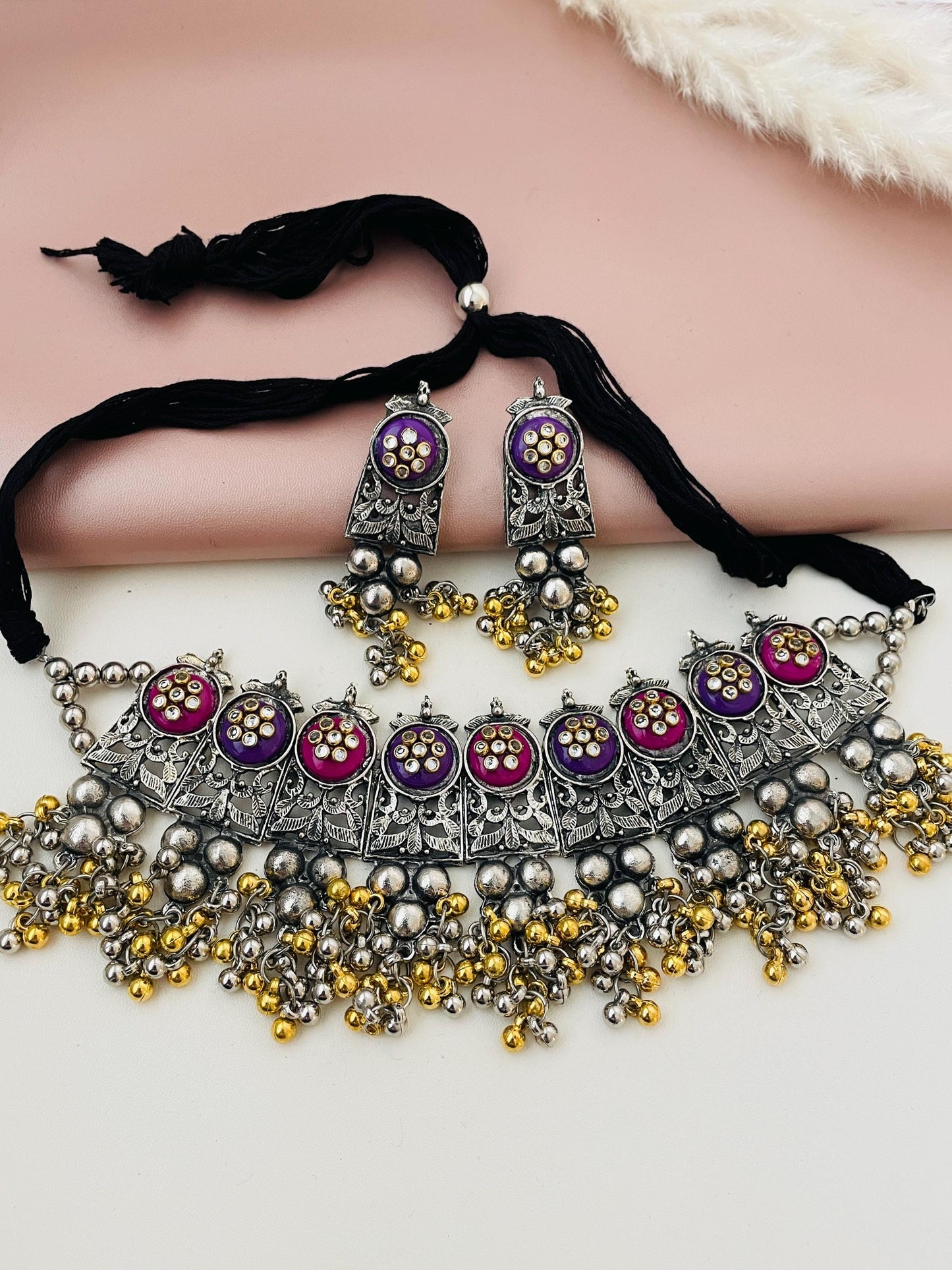 Dual tone Oxidised ghungaroo choker with multiple color option . Comes with matching earrings . Adjustable length