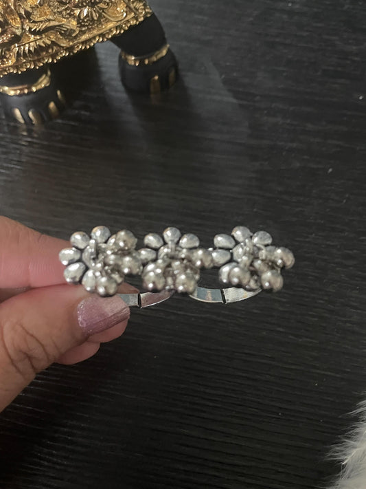 Silver ring with three flower designs. Each flower is made of small, round beads.