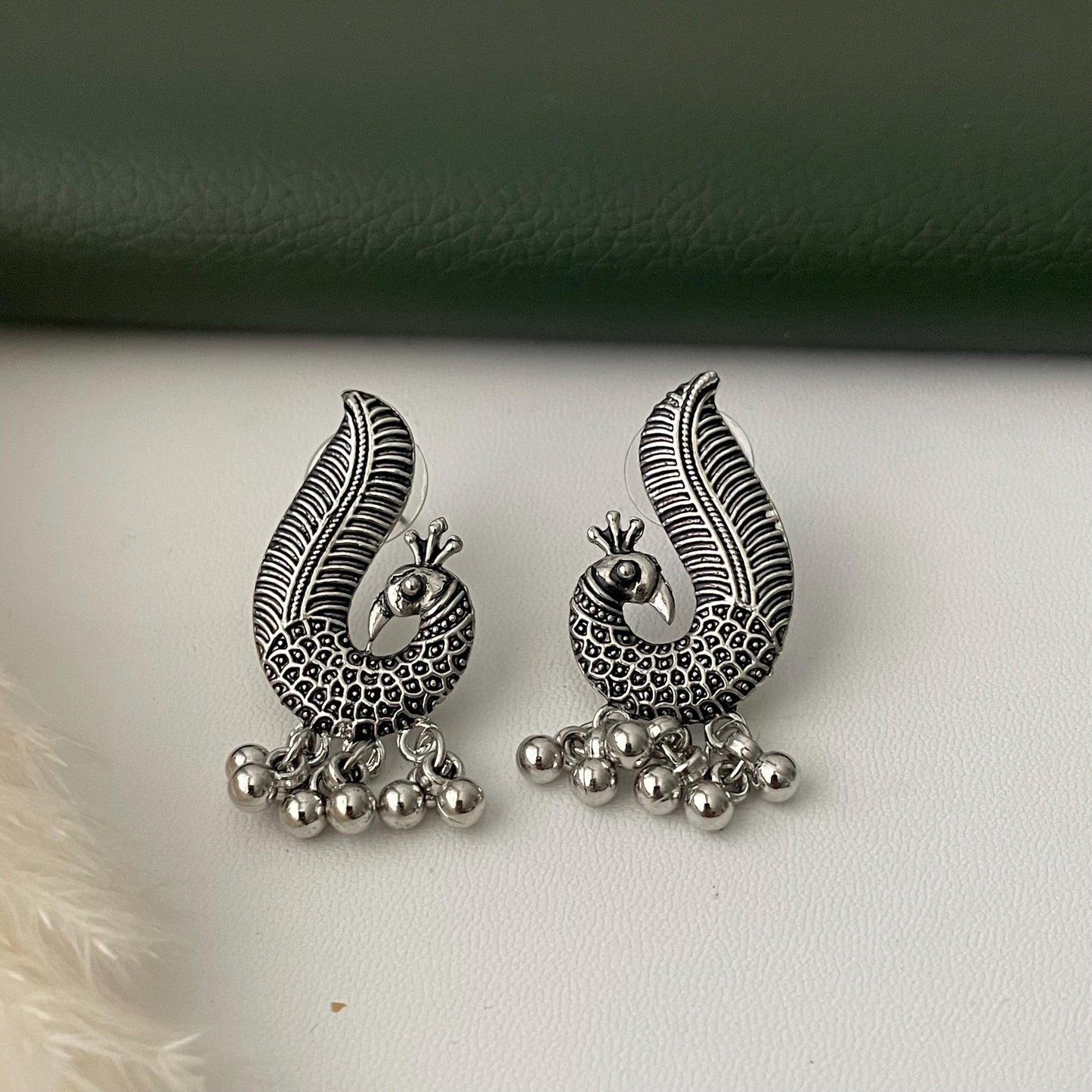 Oxidized earrings in peacock motifs.