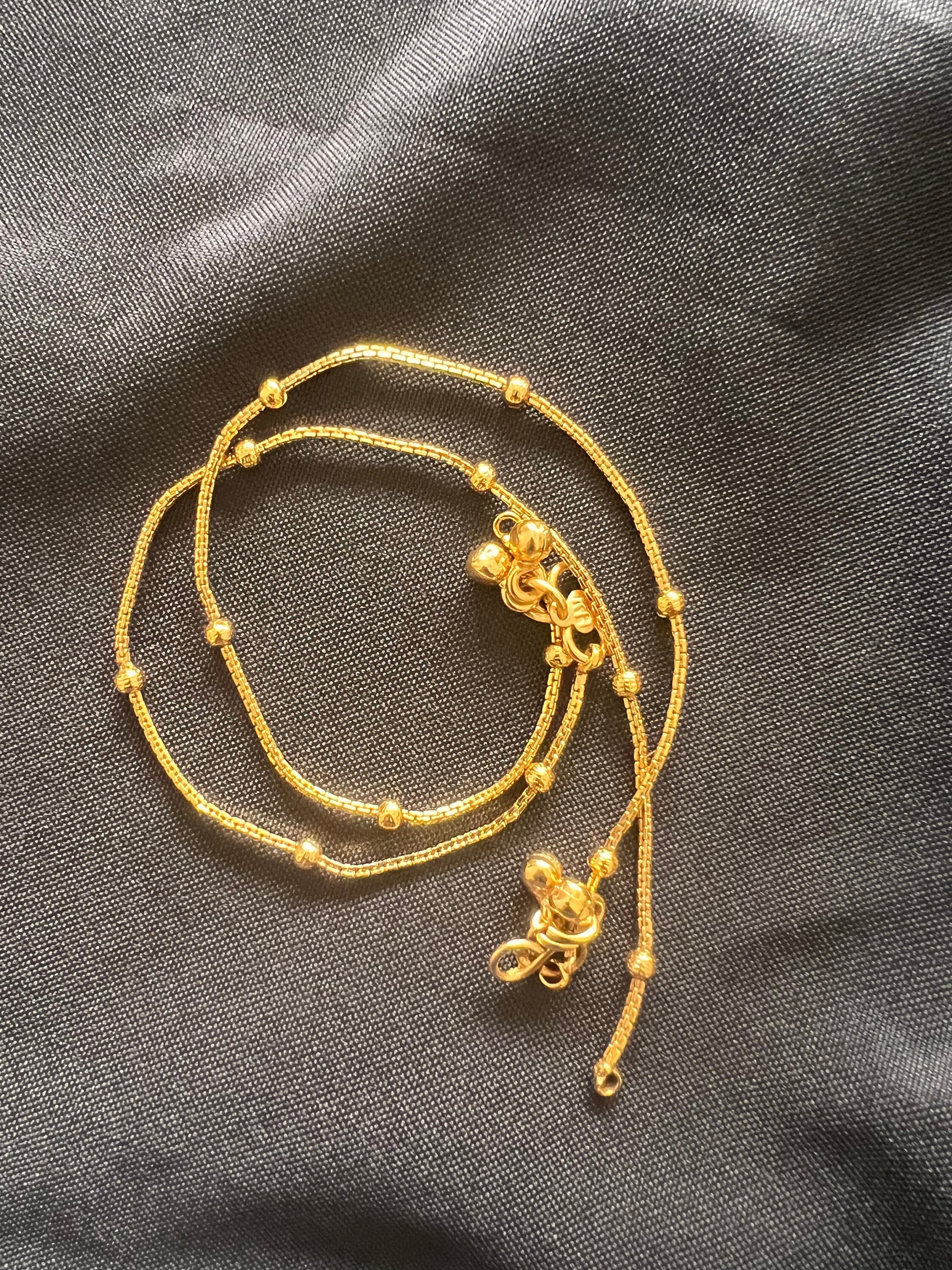 A gold chain anklet with small round beads and two decorative clasps. High gold plated anklets comes in a pair