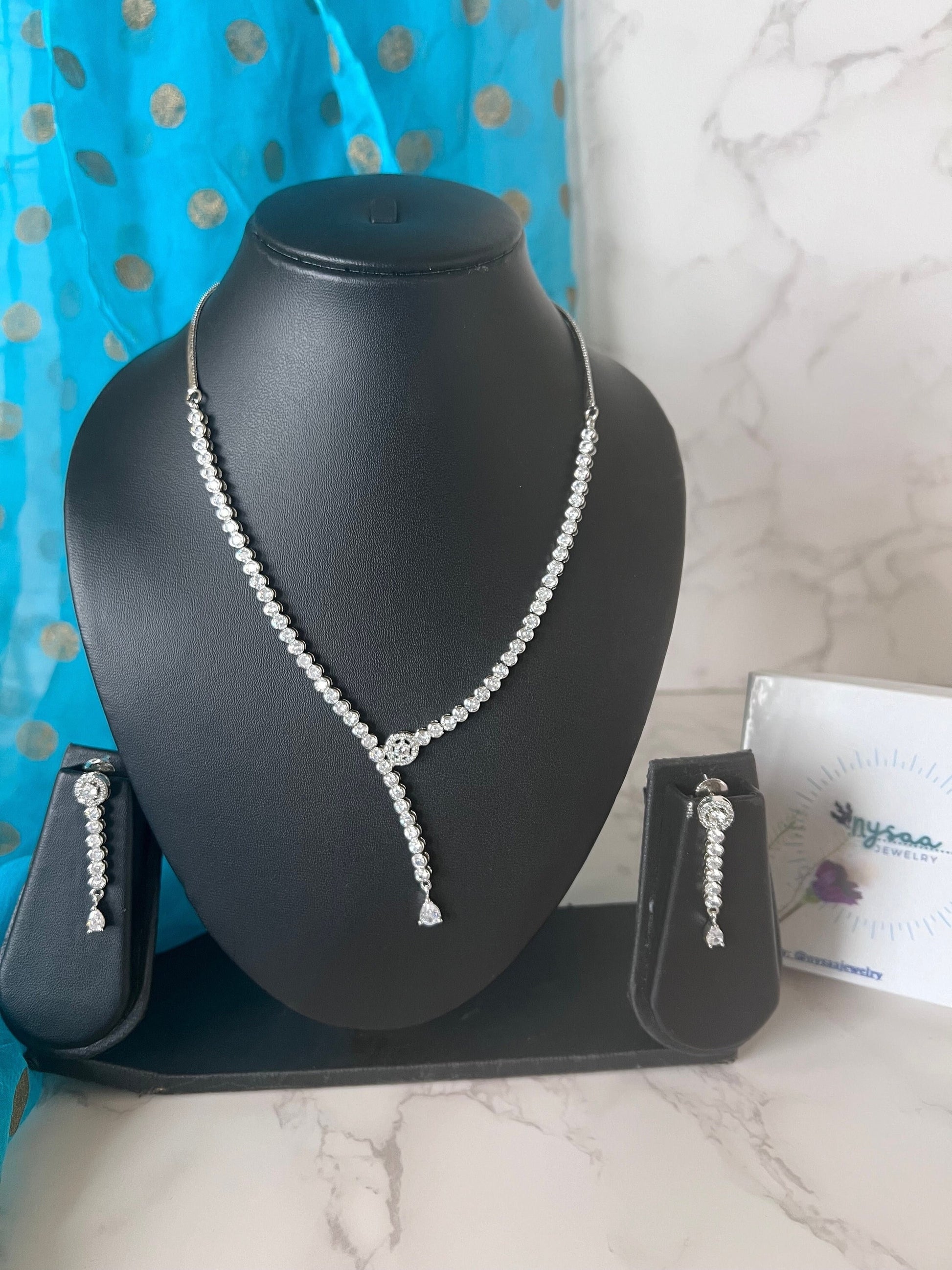 Stunning asymmetrical cubic zirconia necklace set with matching earrings . Rhodium plated perfect for bride , bride mates or mother of bride or groom .