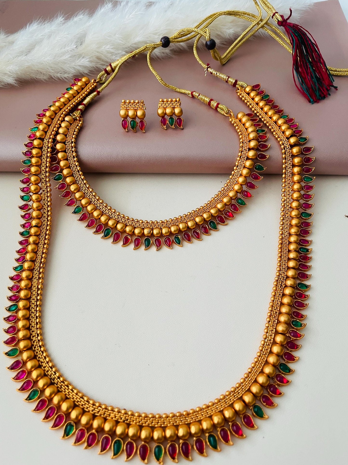 2 layered necklace set  with green n Ruby plastic gems . Really stunning imitation jewelry. Perfectfor dance recitals