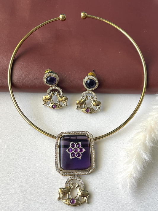 High quality antique gold plated purple hasli necklace with matching earrings. The trendy hasli has a big purple pendant and deer motifs.