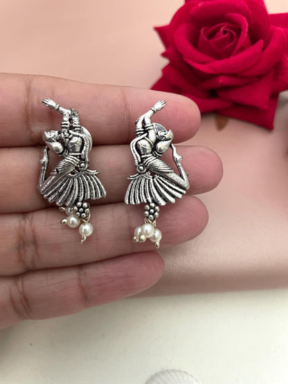 Silver earrings with a detailed design of a woman dancing, accented with small white pearls.