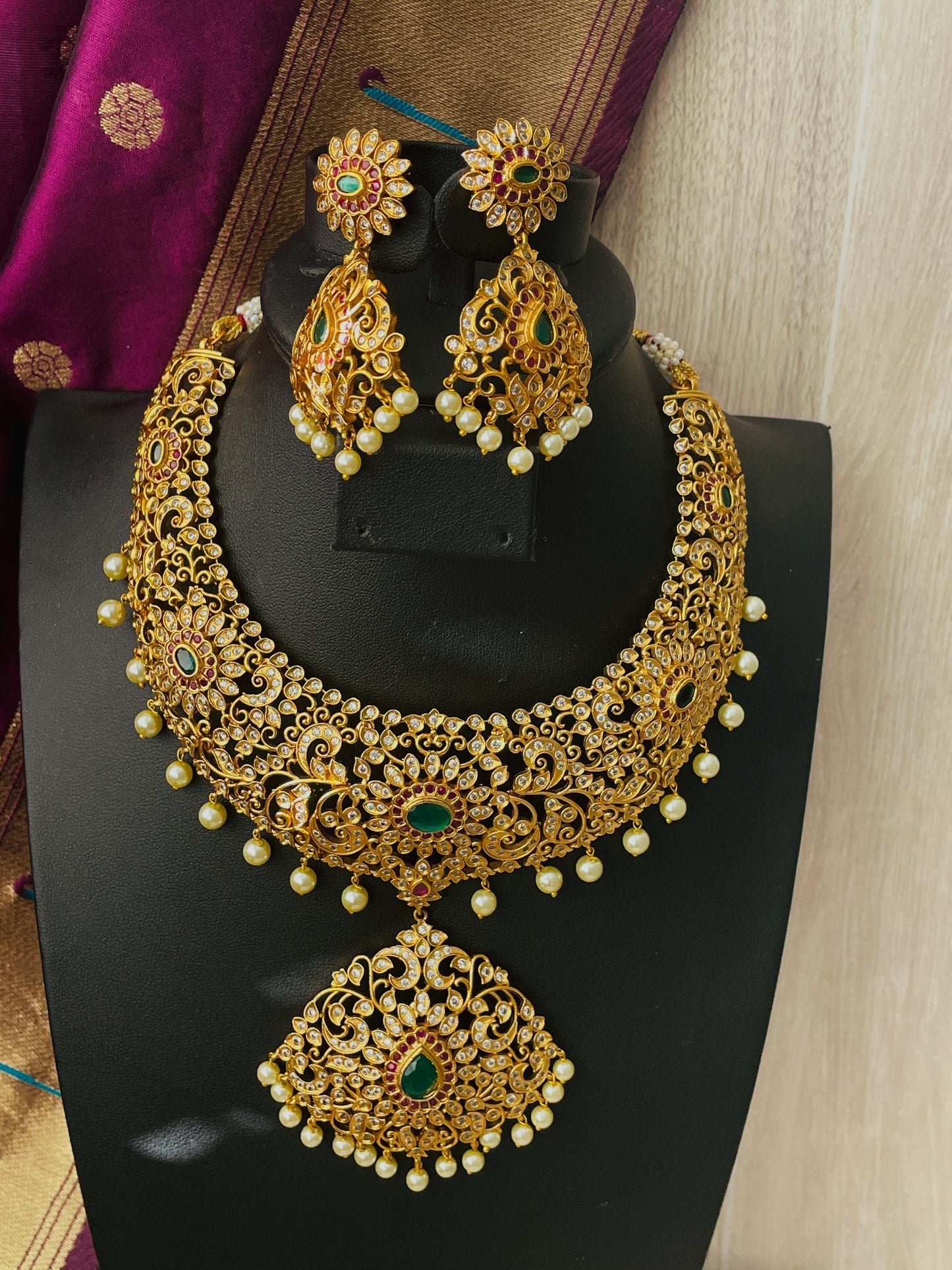 High quality CZ , pearl , Rubyand green gemstones make this necklace very stunning . Comes with matching earrings.Very intricate design perfect for that big day .