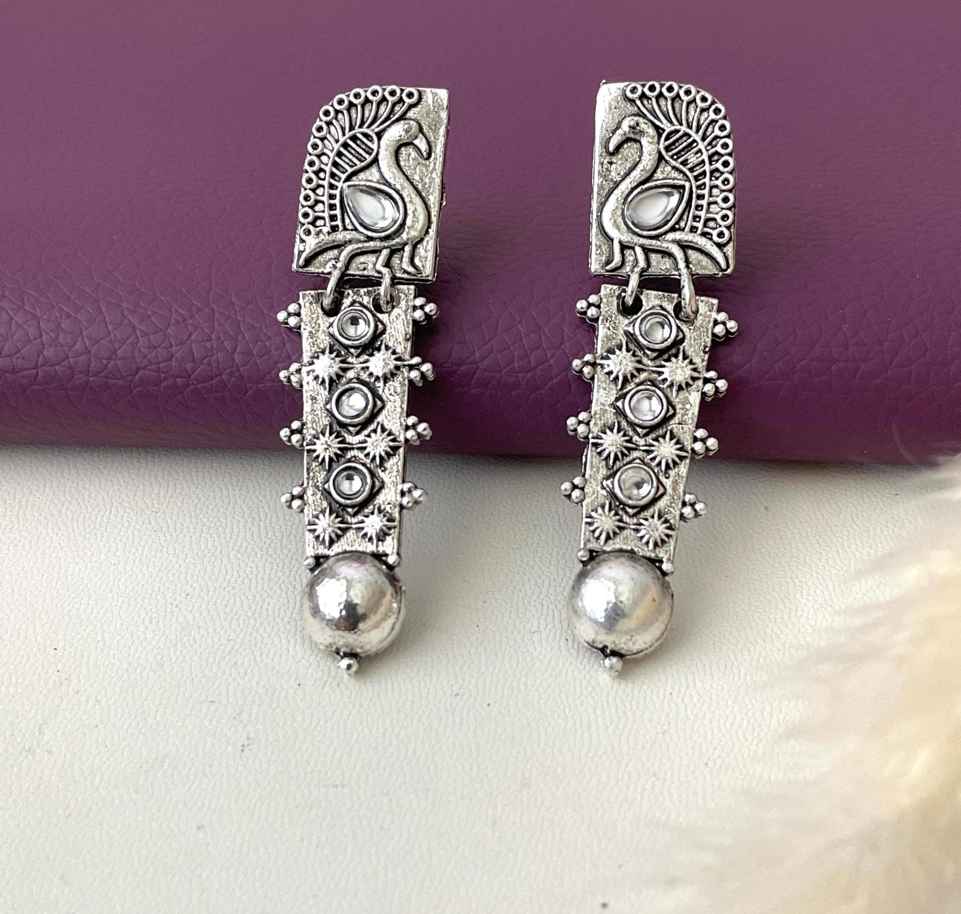 Silver lookalike peacock Oxidised earrings in Ruby and white