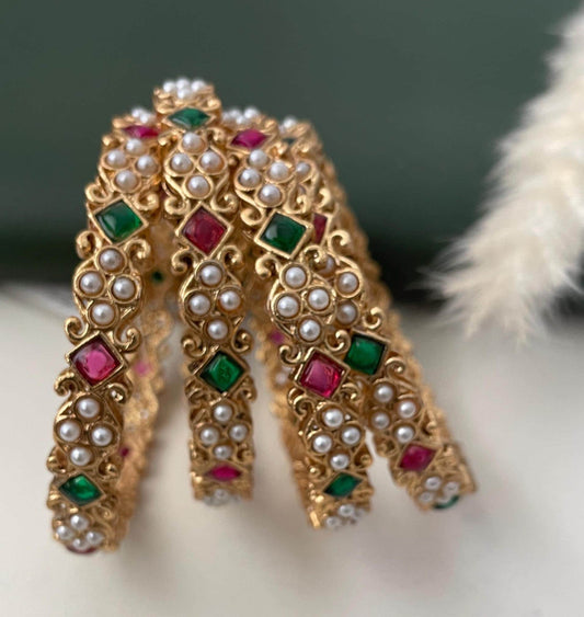 Ruby , green stone and pearl bangles high gold plated . Stunning modern design perfect for festive look