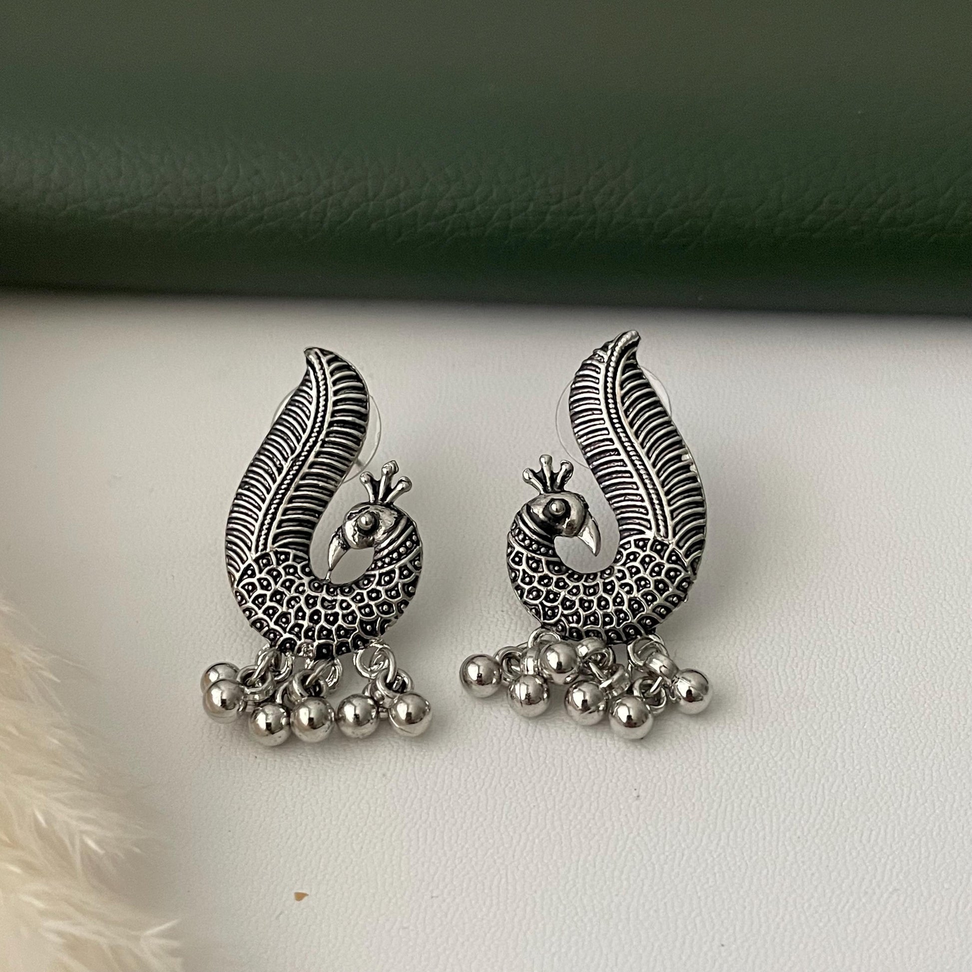 Oxidized earrings in peacock motifs.