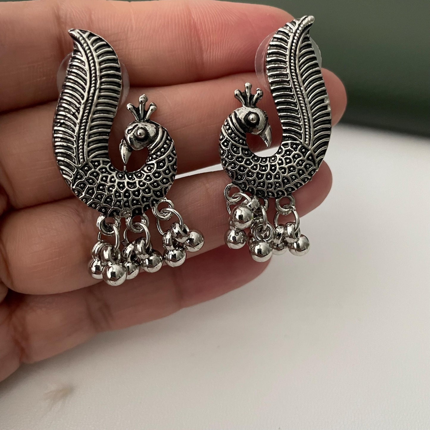 Oxidized earrings in peacock motifs.