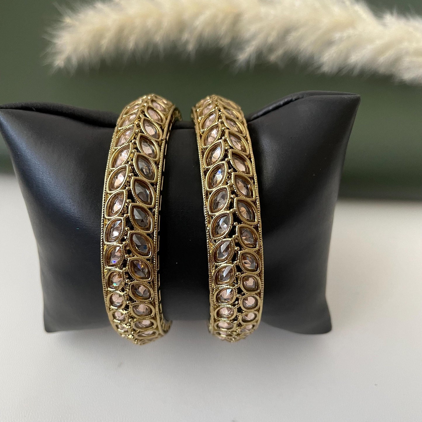Two mehendi plated bangles with clear stones set in a leaf pattern