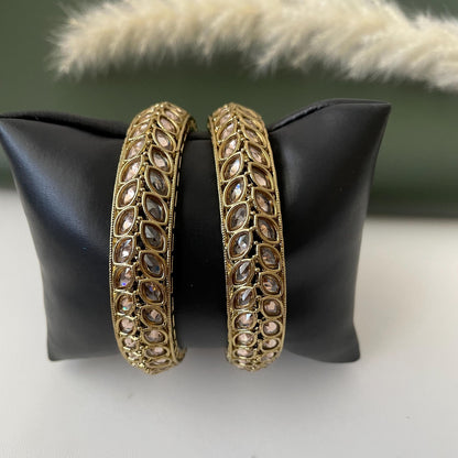 Two mehendi plated bangles with clear stones set in a leaf pattern