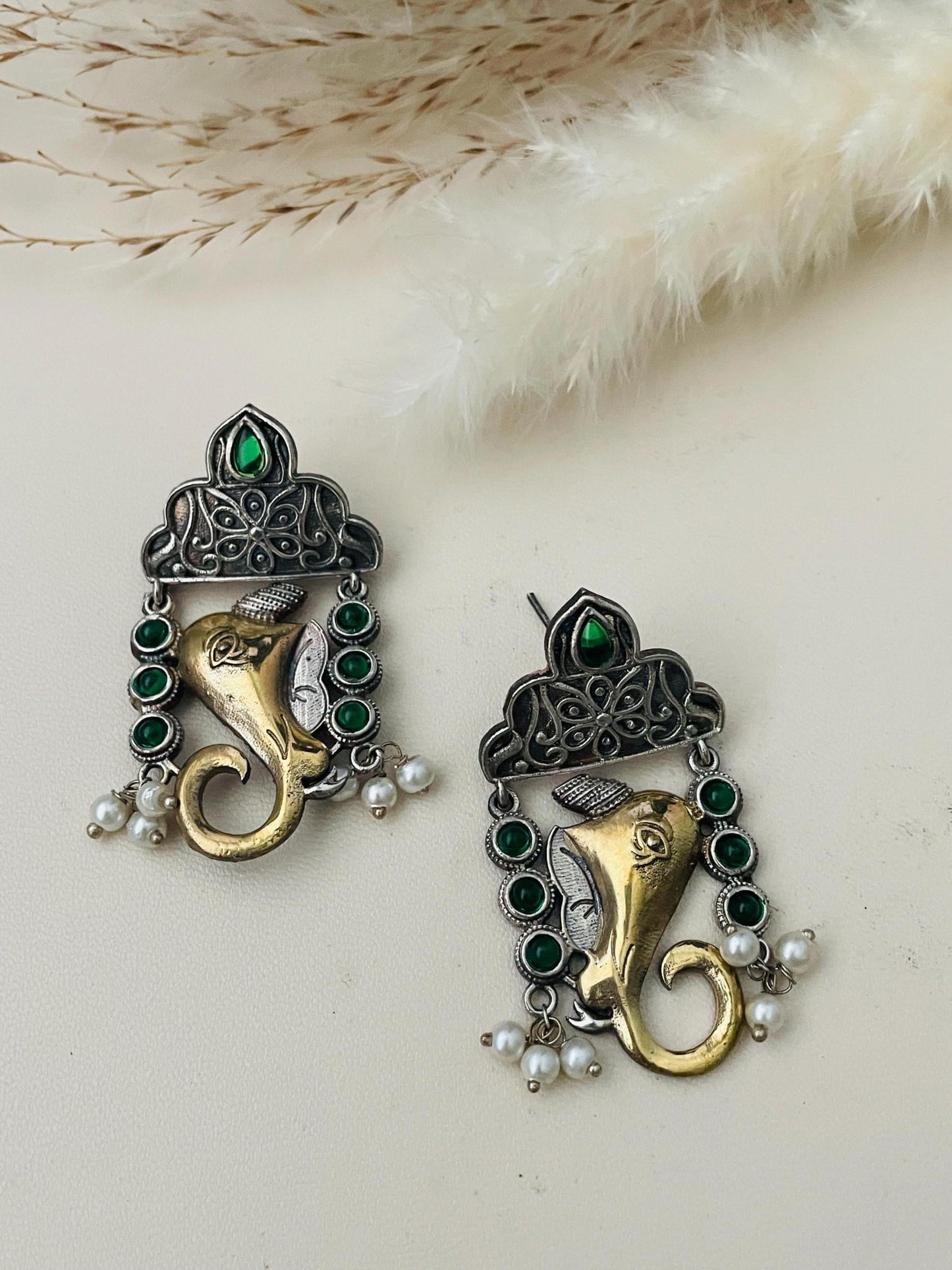 Dual tone Gold and Oxidised Ganapati high quality earrings . Decorated with high quality green gems .