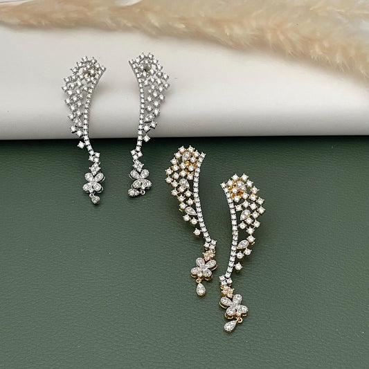 May include: Two pairs of elegant ear climbers. One pair is silver-toned, and the other is gold-toned. Both feature a cascade of small, sparkling stones and floral accents. The earrings are designed to curve up the ear, adding a touch of sophistication.