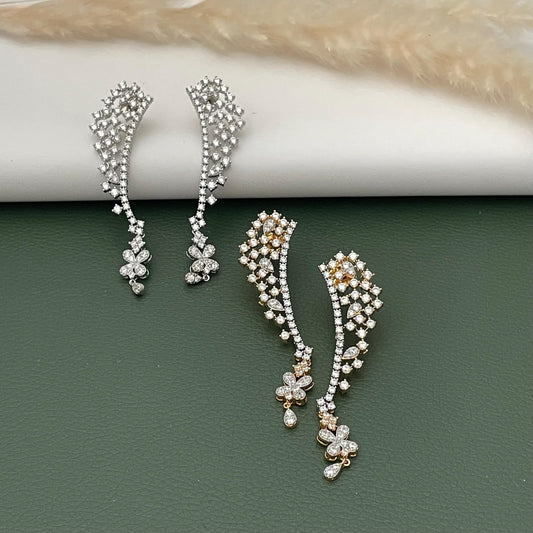May include: Two pairs of elegant ear climbers. One pair is silver-toned, and the other is gold-toned. Both feature a cascade of small, sparkling stones and floral accents. The earrings are designed to curve up the ear, adding a touch of sophistication.